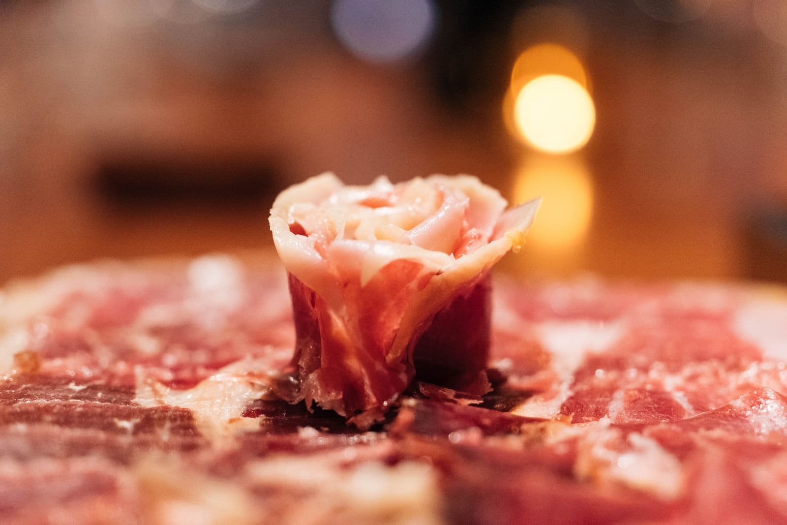 Gros plan sur une fleur de tranches de jambon ibérique Bellota, texture marbrée