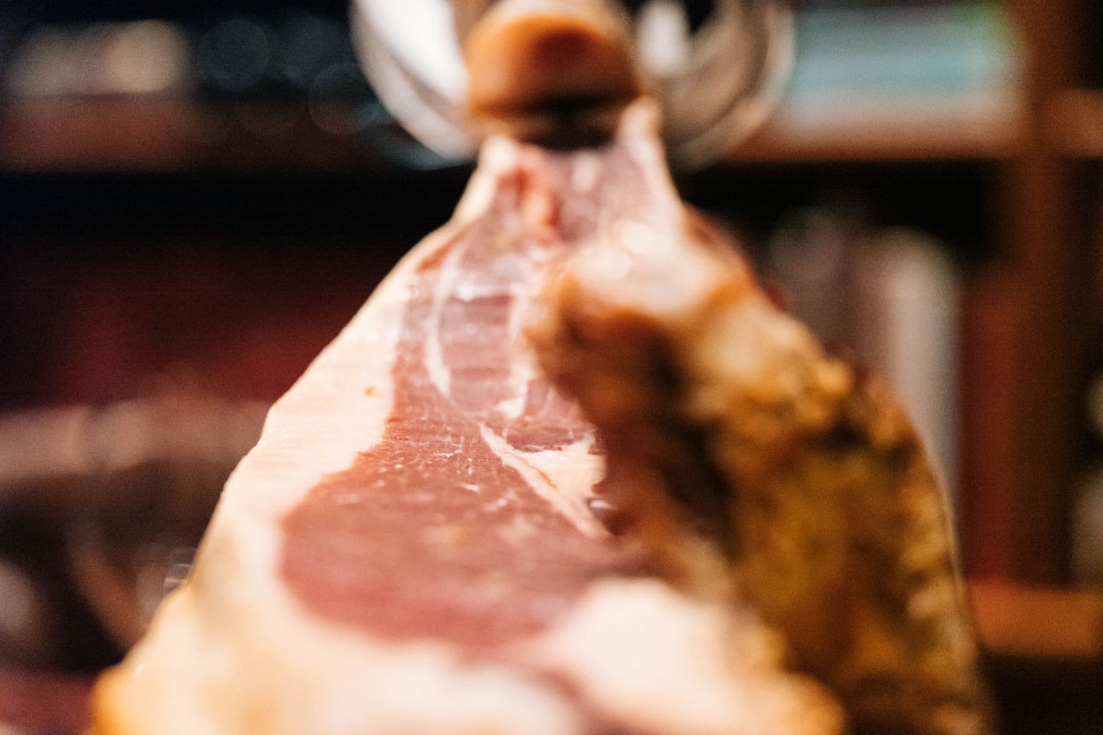 Gros plan sur un jambon ibérique sur son support, effet bokeh