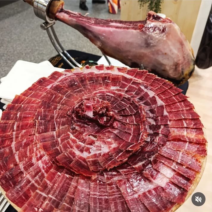 Jambon ibérique sur son support et assiette en rosace, gros plan